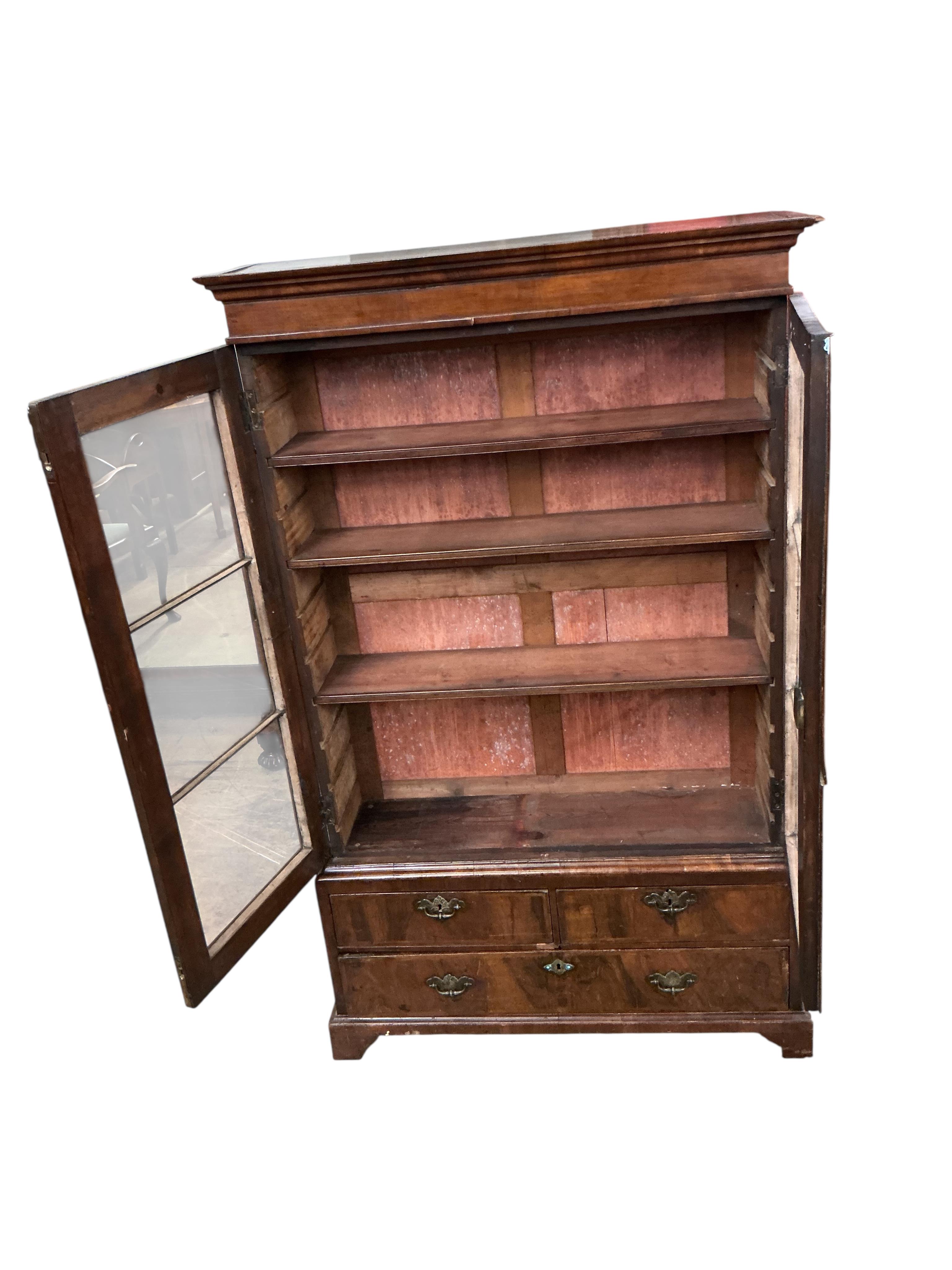 A Queen Anne Revival walnut two door bookcase, the base fitted with drawers, width 92cm, depth 27cm, height 154cm